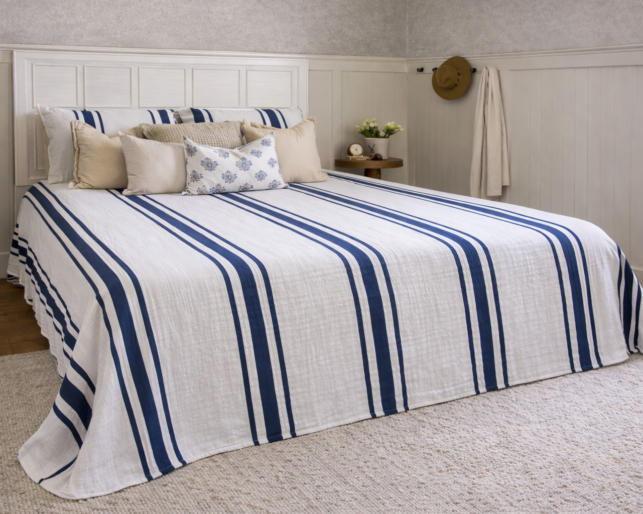 Bed with blue and white striped bedding in a bedroom setting.