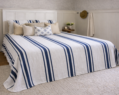Bed with blue and white striped bedding in a bedroom setting.