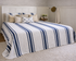 Bed with blue and white striped bedding in a bedroom setting.